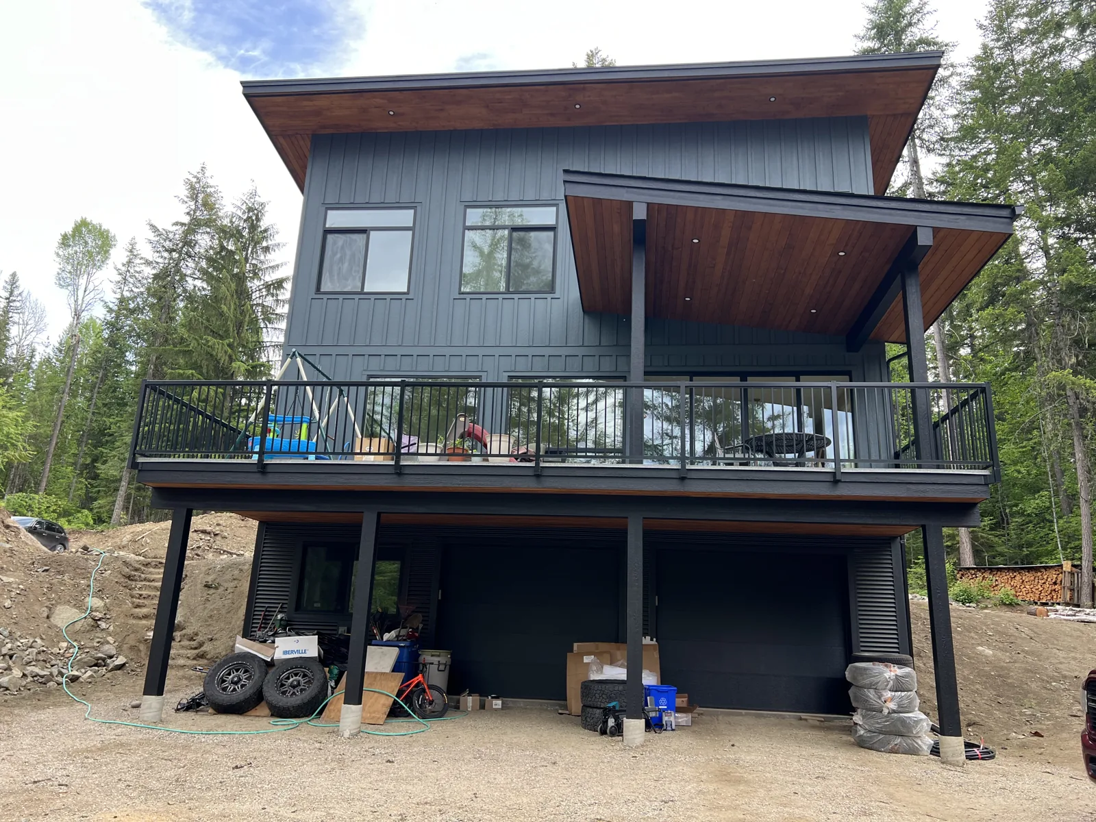 Grey-sided house with timber accents and a covered upper deck