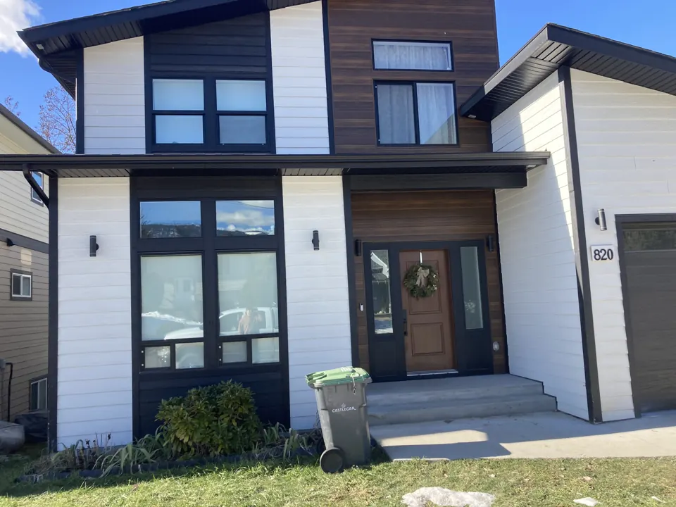 Home exterior with a tall timber-lined covered entry and siding